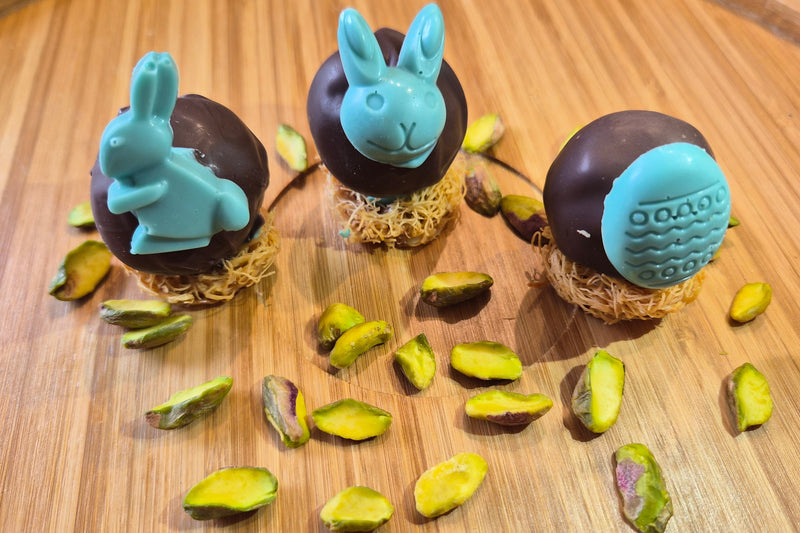 Chocolate-dipped treats with bunny shapes on a wooden surface